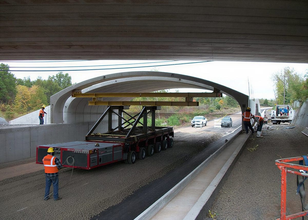 Workers constructing a bridge over a road.
